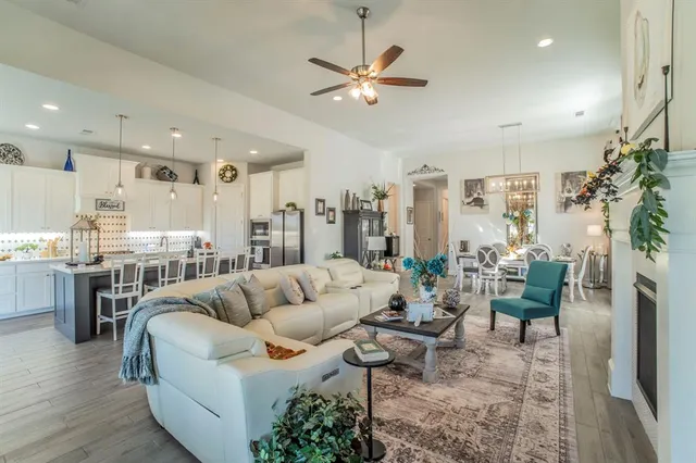 a living room with furniture kitchen view and a large window