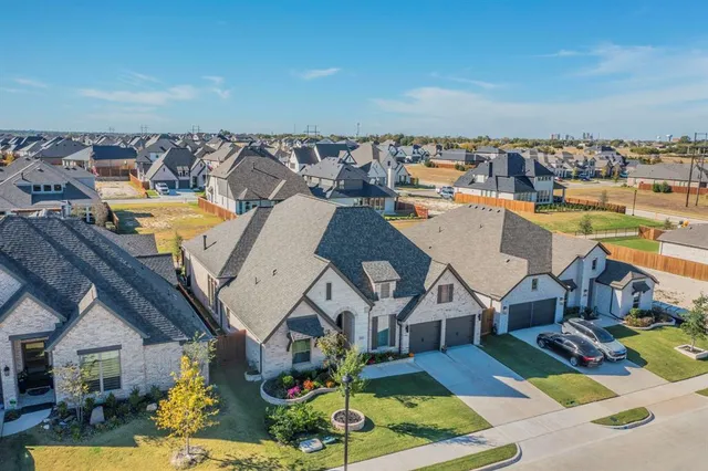 an aerial view of a house with swimming pool outdoor seating and house in the background