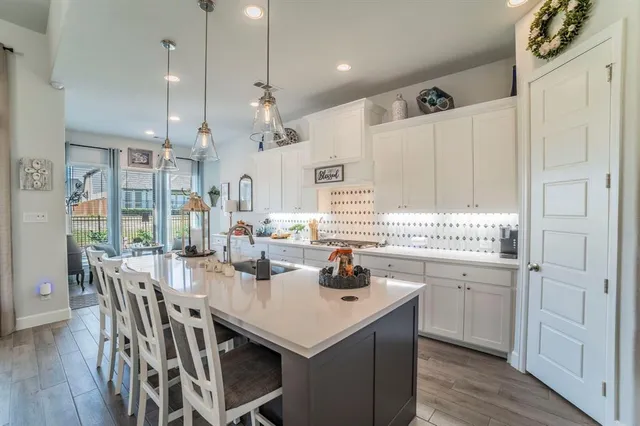 a kitchen with kitchen island a white counter space a sink appliances and cabinets