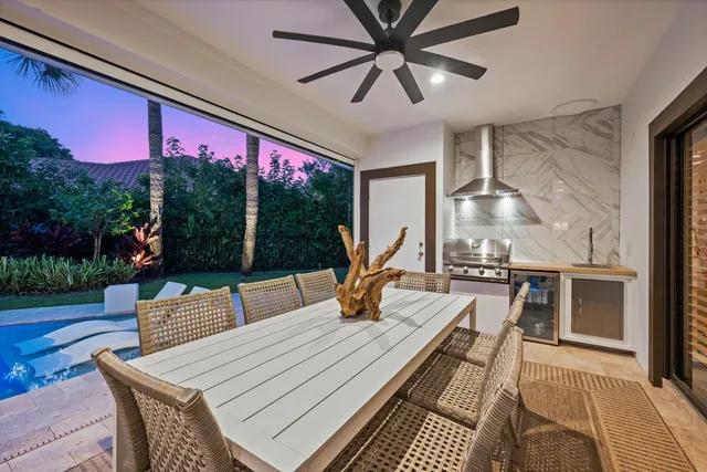 a view of a patio with dining table and chairs with wooden floor and fence