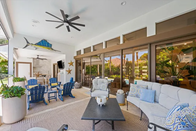 a living room with furniture ceiling fan and a large window