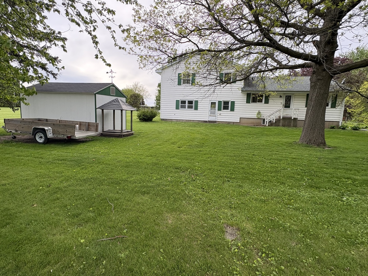 320 South Main Street Creston, IL 61068 - Photo 30 of 34 a view of a house with a big yard and large trees