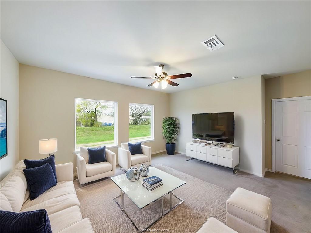 2910 Town Square Avenue, Unit 2607 Bryan, TX 77802 - Photo 2 of 7 a living room with furniture a flat screen tv and a large window