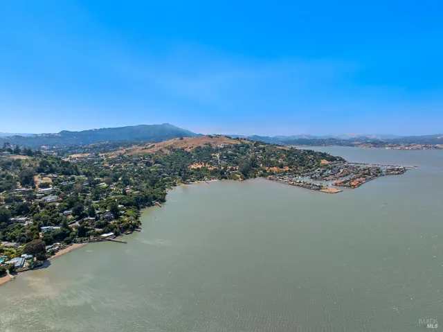 an aerial view of ocean and residential houses with outdoor space