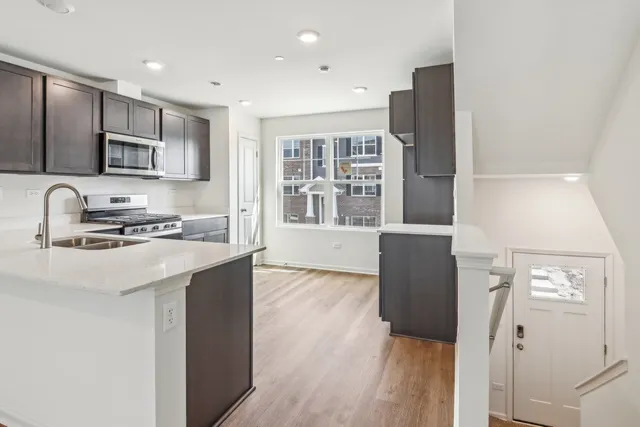 a kitchen with stainless steel appliances granite countertop a sink stove and refrigerator