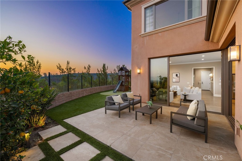 a view of a patio with couches table and chairs and potted plants