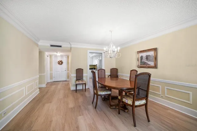 a dining room with furniture a chandelier and wooden floor