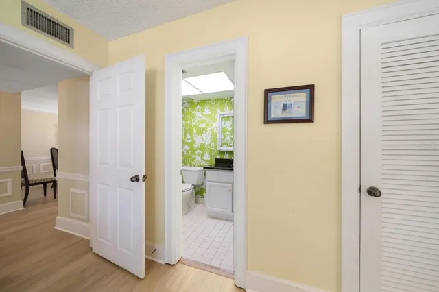 a view of a hallway with bathroom and wooden floor