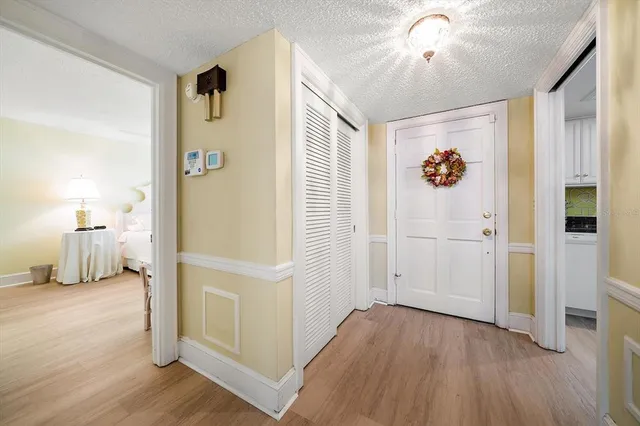 a view of a hallway with wooden floor and closet