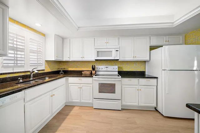 a kitchen with white cabinets and white appliances