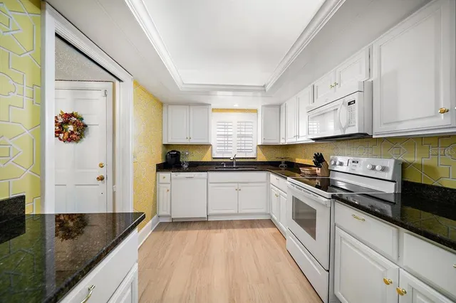 a kitchen with granite countertop a sink stainless steel appliances and cabinets
