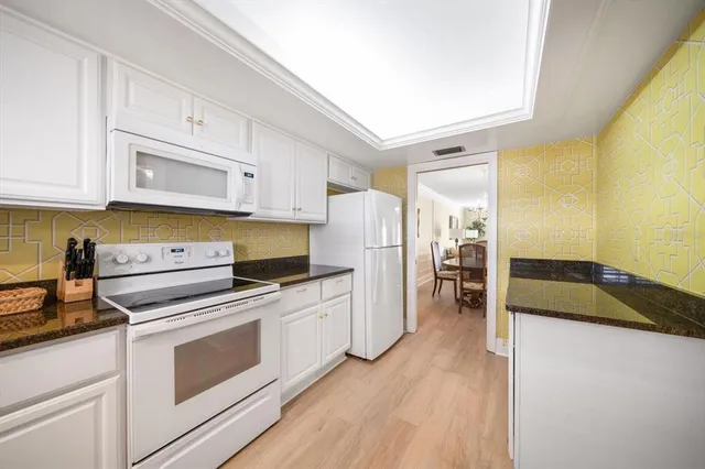 a kitchen with a refrigerator stove and white cabinets