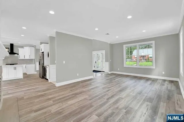 a view of a big room with wooden floor and windows