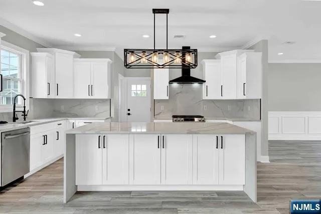 a kitchen with stainless steel appliances granite countertop a sink a stove and cabinets