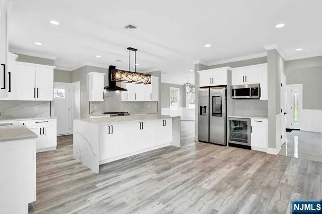 a large kitchen with cabinets wooden floor and stainless steel appliances