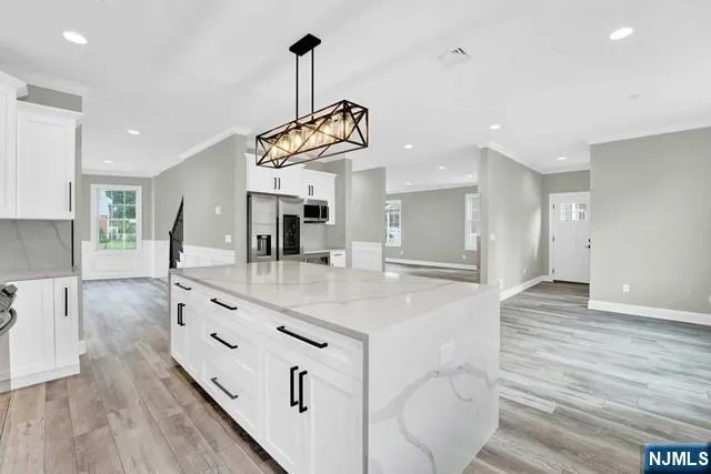 a kitchen with stainless steel appliances granite countertop a sink window and wooden floor