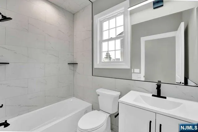 a bathroom with a sink toilet vanity and bathtub