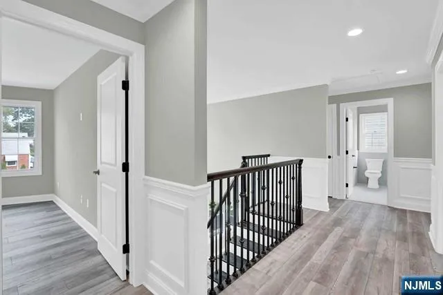 a view of a hallway with wooden floor and stairs