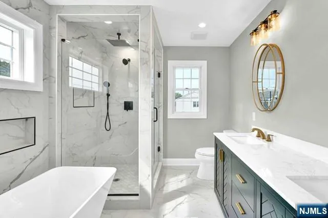 a bathroom with a tub a sink and a mirror