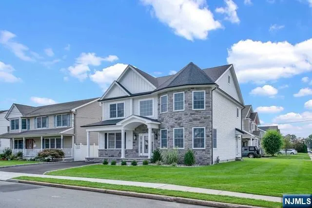 a view of a big house with a big yard and large trees