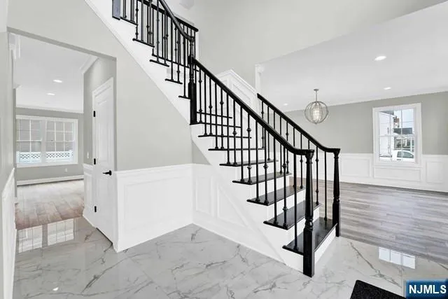 a view of staircase with lots of frames and white walls