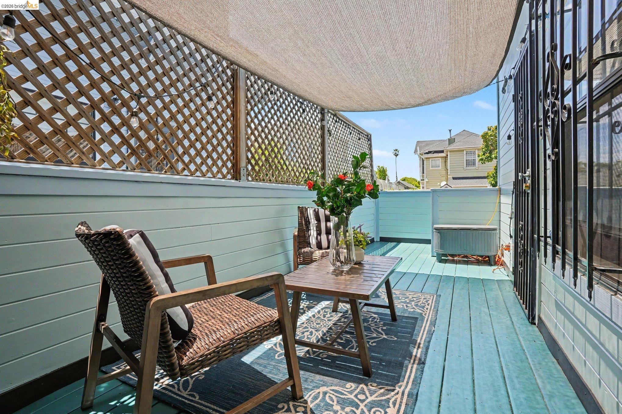1433 Myrtle Street Oakland, CA 94607 - Photo 21 of 25 Outdoor deck featuring light blue plank flooring, a lattice privacy screen, and a fabric overhead shade