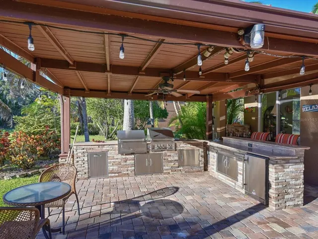 a view of a patio with table and chairs potted plants with floor to ceiling window and wooden floor