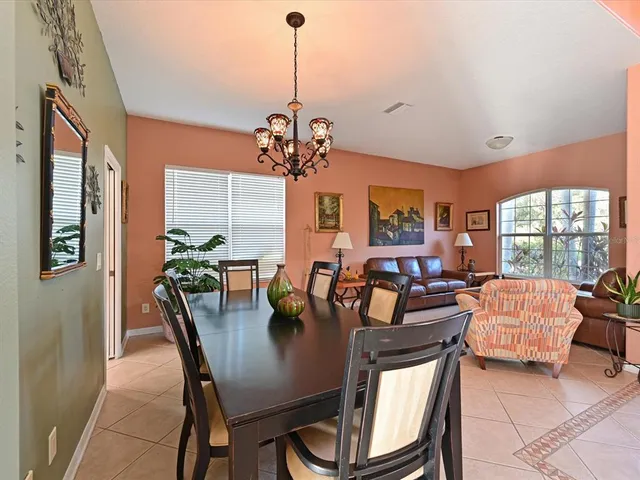 a view of a dining room with furniture a livingroom and chandelier