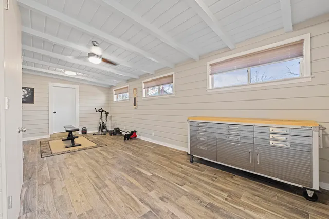 a room with gym equipment and wooden floor