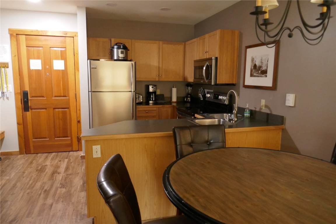 100 Dercum Square, Unit 8374 Keystone, CO 80435 - Photo 5 of 24 a kitchen with wooden cabinets a refrigerator stove and microwave