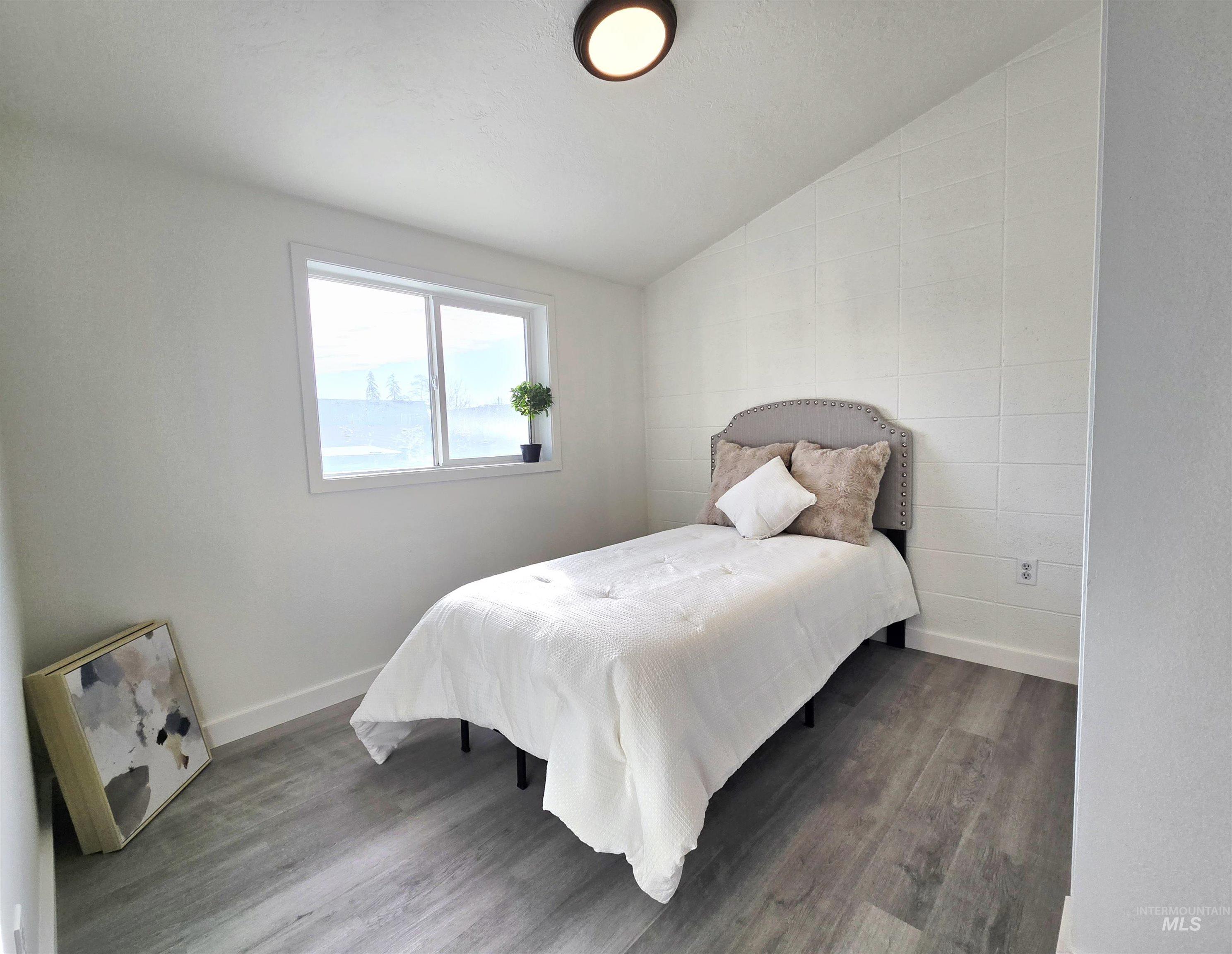 728 Northwest 8th Street Meridian, ID 83642 - Photo 13 of 18 Bedroom featuring vaulted ceiling and wood finished floors