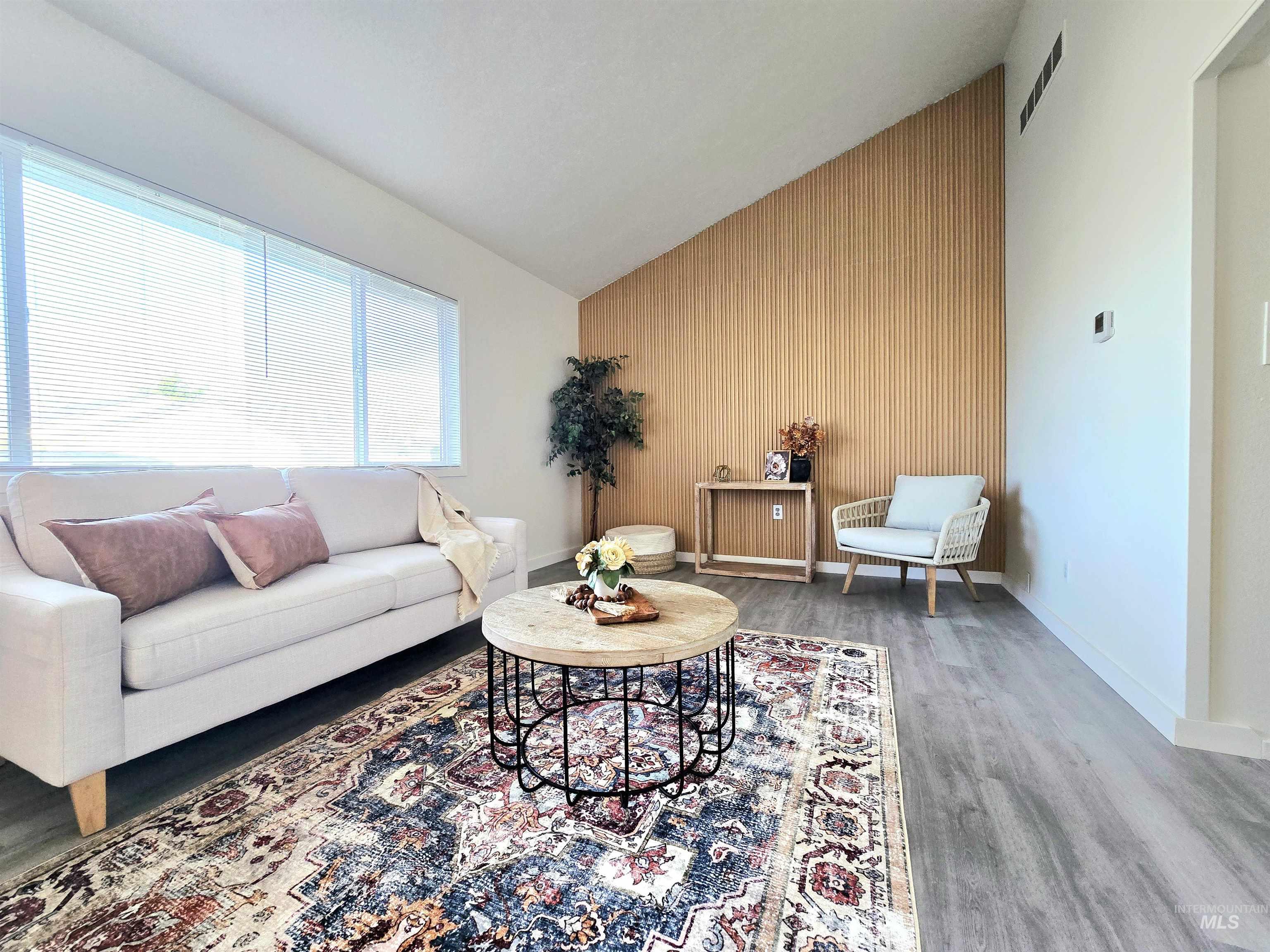 728 Northwest 8th Street Meridian, ID 83642 - Photo 3 of 18 Living area featuring an accent wall, lofted ceiling, and wood finished floors