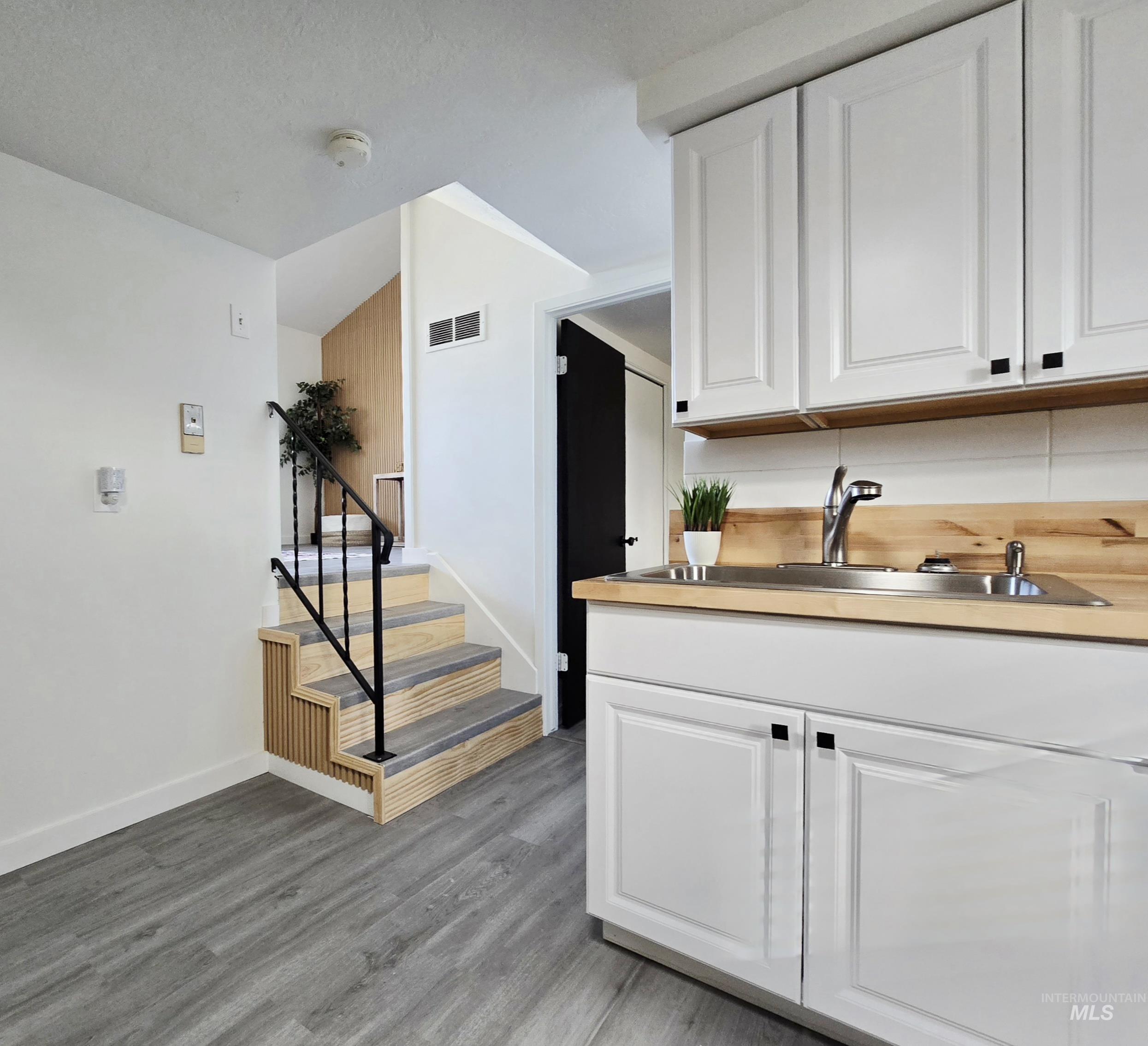 728 Northwest 8th Street Meridian, ID 83642 - Photo 6 of 18 Kitchen featuring white cabinets, dark wood-style flooring, and lofted ceiling