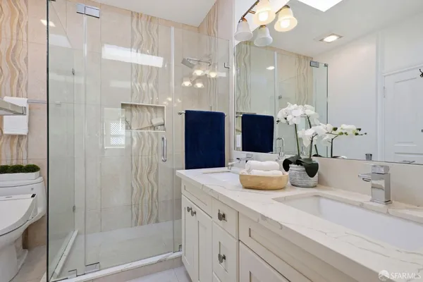 a bathroom with a sink a toilet and shower