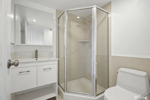 a bathroom with a shower sink mirror and toilet