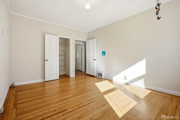 a view of an empty room with wooden floor