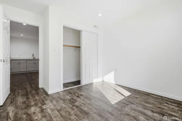 a view of empty room with wooden floor and cabinet