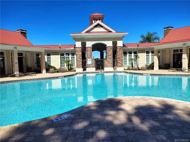 a view of swimming pool with two chairs in a patio