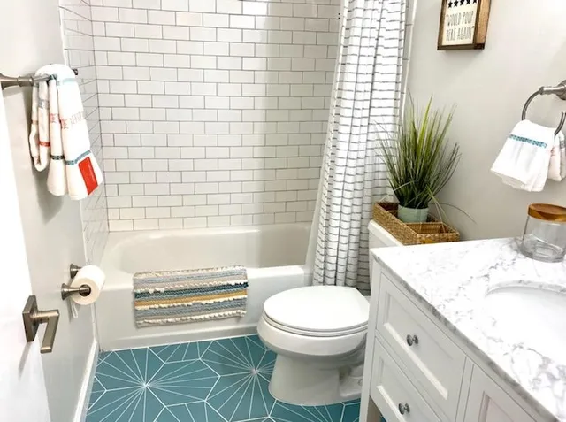 a bathroom with a granite countertop bathtub sink vanity mirror and toilet