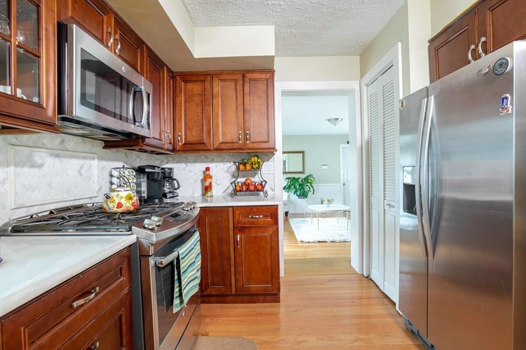 50 Forest Street Bridgewater, MA 02324 - Photo 19 of 42 a kitchen with stainless steel appliances granite countertop a refrigerator a stove and a sink with wooden cabinets
