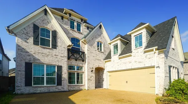 a view of a white house with large windows and a small yard