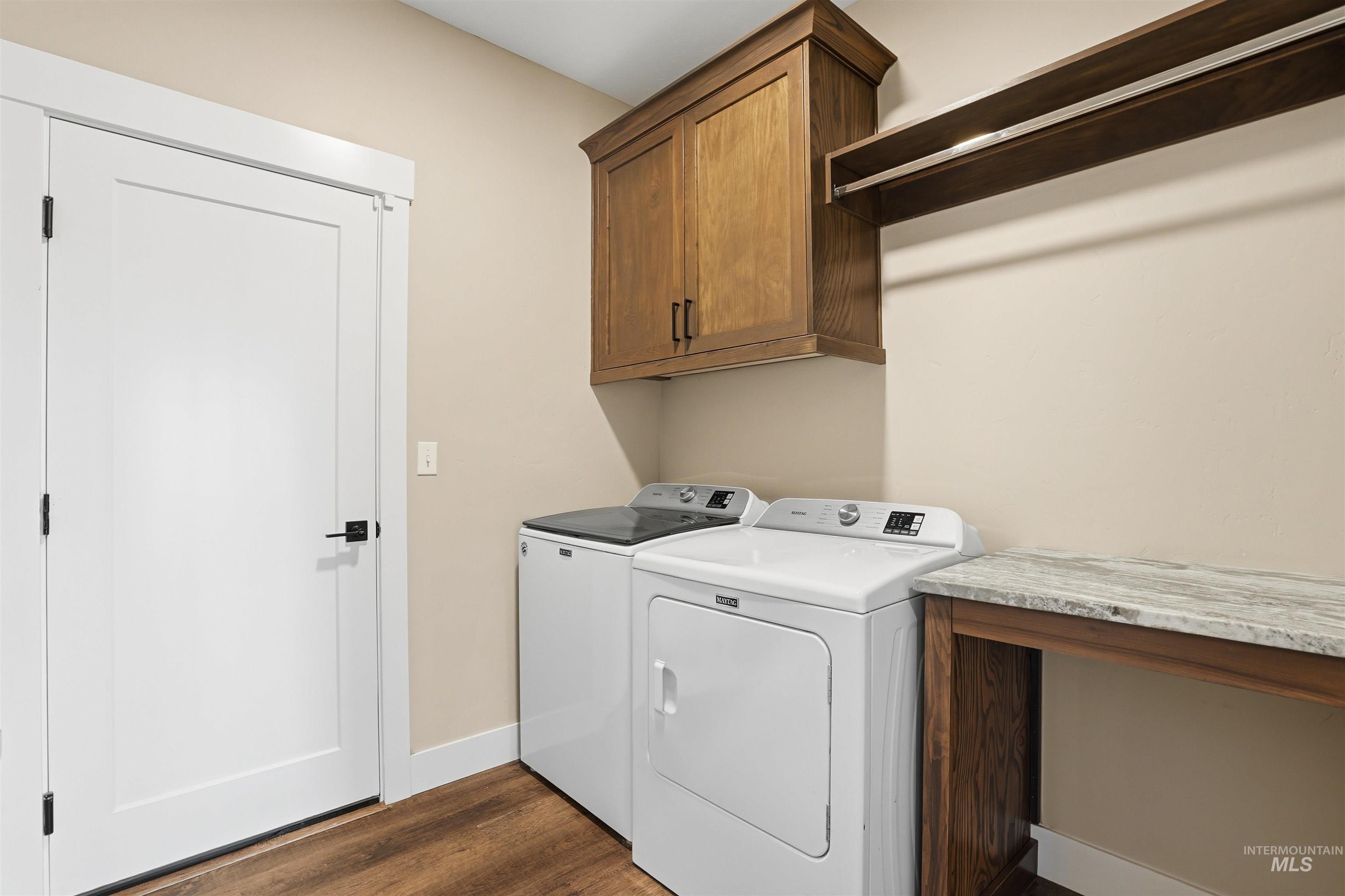 6617 Red Rock Road Marsing, ID 83639 - Photo 25 of 39 Laundry room featuring dark wood finished floors, washing machine and clothes dryer, and cabinet space