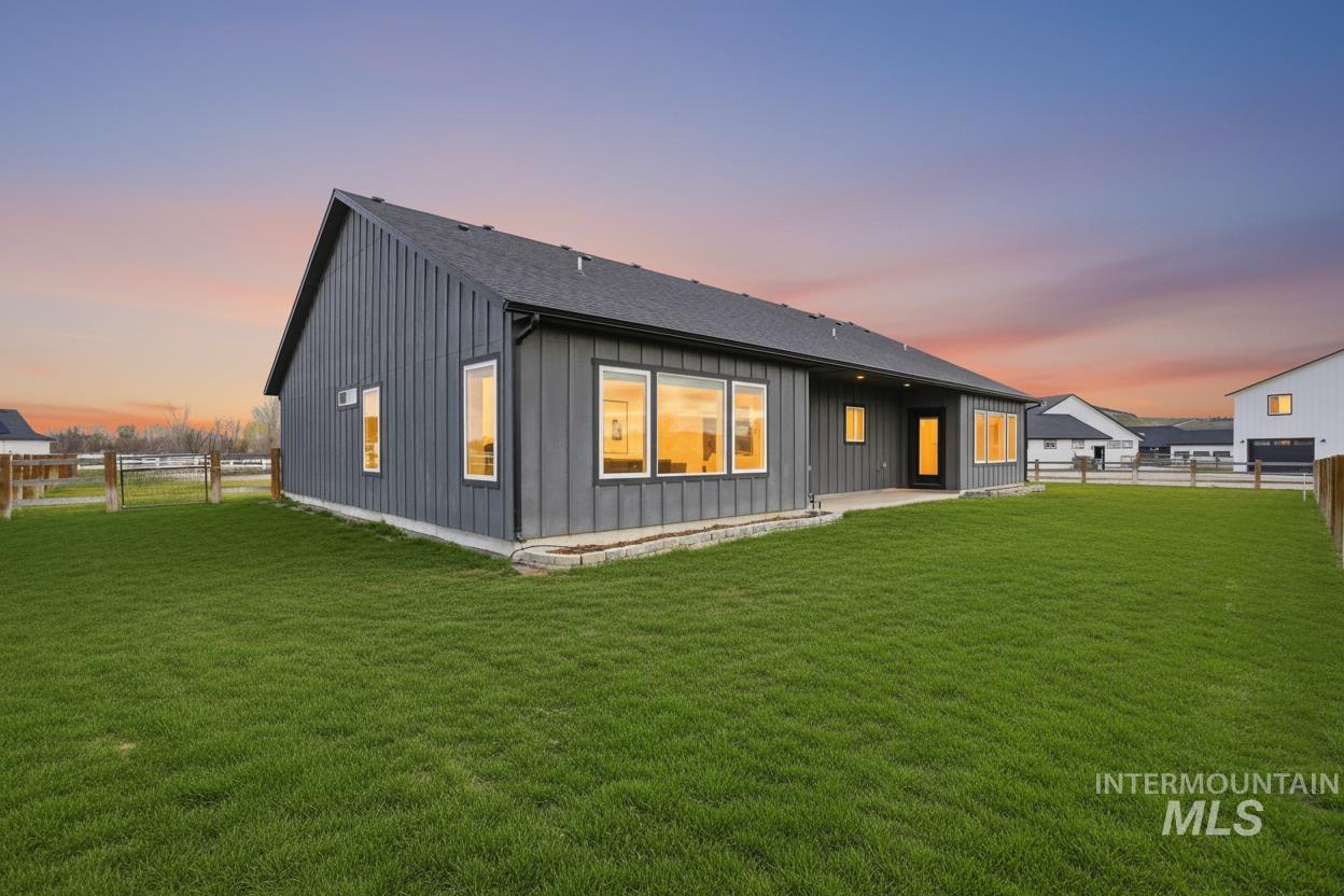 6617 Red Rock Road Marsing, ID 83639 - Photo 35 of 39 Rear view of house featuring a patio, a fenced backyard, and board and batten siding