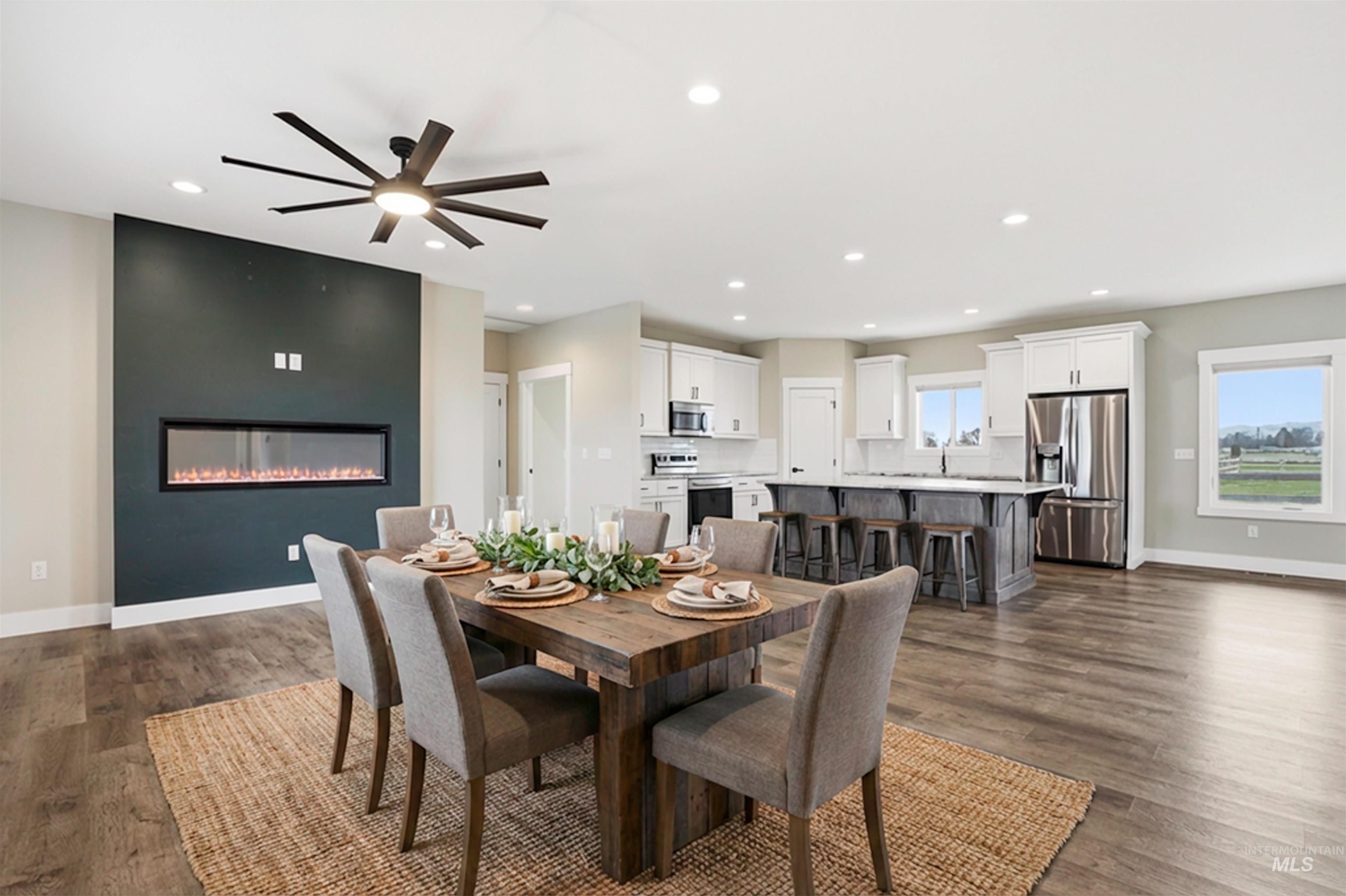 6617 Red Rock Road Marsing, ID 83639 - Photo 6 of 39 Dining room featuring a ceiling fan, a large fireplace, dark wood-style flooring, and recessed lighting
