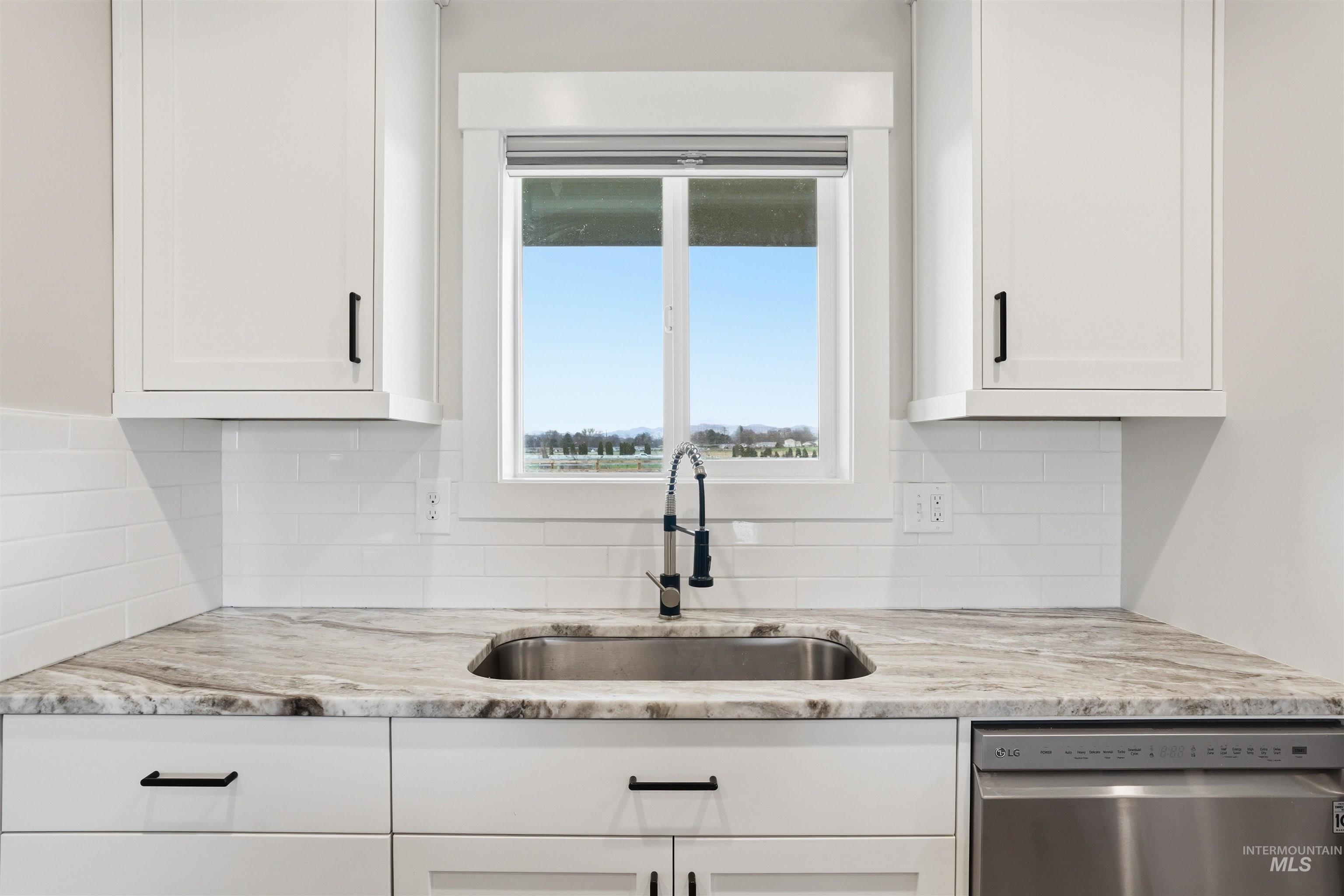 6617 Red Rock Road Marsing, ID 83639 - Photo 9 of 39 Kitchen featuring dishwasher, white cabinetry, and light stone counters