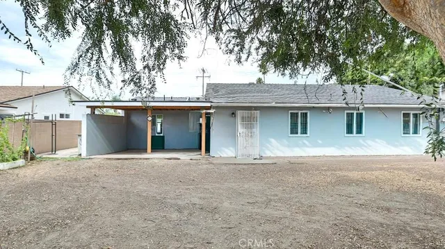 a front view of a house with a tree