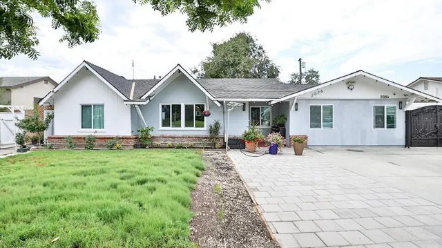 a view of a house with backyard sitting area and garden