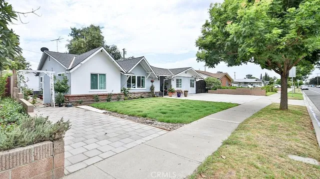 a front view of a house with a yard and trees