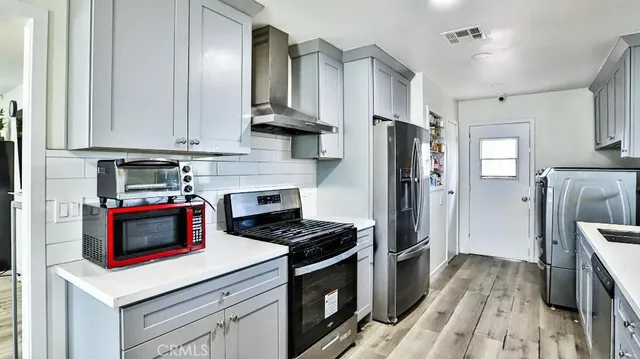 a kitchen with stainless steel appliances a stove a refrigerator and cabinets
