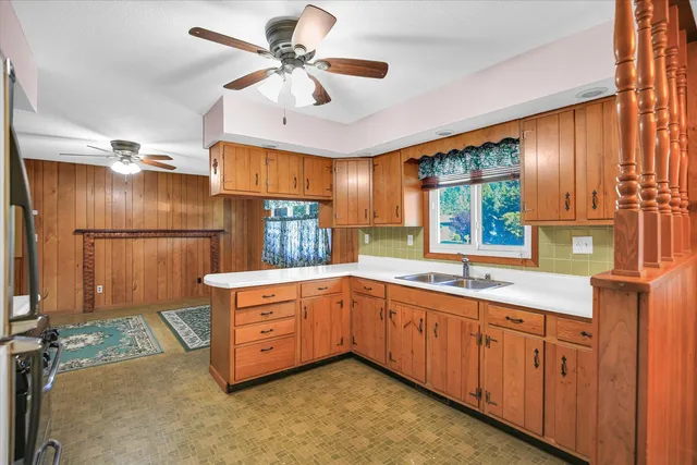 a kitchen with granite countertop a sink appliances cabinets and a window